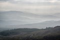 Landscape view from top of mountain on misty morning across countryside with fading layers