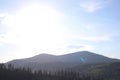 landscape view of the Ukrainian mountains with small houses, white swings and green firs and a blue sky with clouds. for postcards