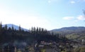 landscape view of the Ukrainian mountains with small houses, white swings and green firs and a blue sky with clouds. for postcards