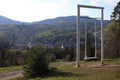 landscape view of the Ukrainian mountains with small houses, white swings and green firs and a blue sky with clouds. for postcards