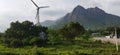 Landscape view with a windmill, mountain and cloudy sky background Royalty Free Stock Photo