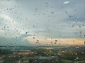 A landscape view from a window with raindrops.