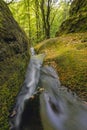 Landscape Of The Water Cascades Of A Mountain Stream. The River Flows Through Mossy Rocks Surrounded By A Beautiful Forest.