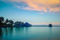 Landscape of water house on stilts, pontoon and palm trees at sunset Royalty Free Stock Photo