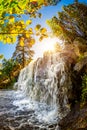 Waterfall in the forest with bright sun in the background Royalty Free Stock Photo