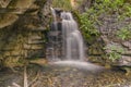 Landscape of a waterfall framed by rocks and foliage, Kananaskis, Alberta