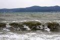 Landscape with waves and mountains on island.