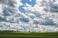 Landscape with Wheat Field and Cloudy Blue Sky in Background. Sunlight and Wide Shadows Area. Royalty Free Stock Photo