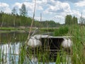 A white rubber boat on an overgrown river bank Royalty Free Stock Photo