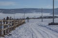 Landscape of pathway in snow with wooden fence in village at Khovsgol