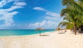 Landscape Wide angle sunny beach with blue sea water, white sand, coconut trees, blue sky with beautiful white clouds, leaf huts Royalty Free Stock Photo