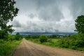 Landscape with a wide forest road and a sky with storm clouds Royalty Free Stock Photo