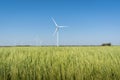 Landscape with wind generator turbine in green field wheat and blue sky background Royalty Free Stock Photo