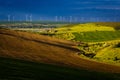 Landscape with wind turbines. Green field and freshly ploughed field. Location: Romania Royalty Free Stock Photo