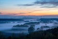 Landscape of windmills on hills covered in the fog during the sunrise Royalty Free Stock Photo