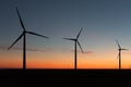 A landscape with windmills in a wind farm at sunset generating alternative and green energy source Royalty Free Stock Photo