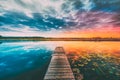 Landscape With Wooden Boards Pier On Calm Water Of Lake, River At Sunset Time, Forest On Other Side. Summer To Autumn Royalty Free Stock Photo