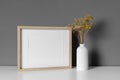 Landscape wooden picture frame mockup with dry flowers in minimalistic style room interior Royalty Free Stock Photo