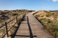 Landscape with a wooden walk way crossing a wild beach Royalty Free Stock Photo