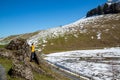 Landscape of a young man standing among the rocks in the mountains with a little snow