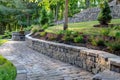 Landscaped backyard with stone retaining walls and a variety of plants