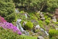 Landscaped english garden with stone waterfall in spring Royalty Free Stock Photo