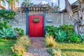 Landscaped garden with pathway inside white fence and red gate with pergola Royalty Free Stock Photo