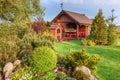 Landscaped summer garden with barbecue and wooden summerhouse Green trees, flowerbeds,