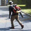 Landscaper using an leaf air blower on a driveway