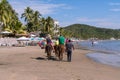 Tourists walk on horses on the beach of Manzanillo Colima.