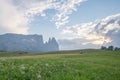 Landscapes on Alpe di Siusi with Schlern Mountain Group in Background and small cabins on the grassland in Summer during the sunse