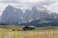 Landscapes on Alpe di Siusi with Schlern Mountain Group in Background and small cabins on the grassland in Summer during the sunse Royalty Free Stock Photo