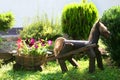 Landscaping. Decorative wooden horse with a cart. Flowerbed with flowers.