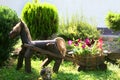 Landscaping. Decorative wooden horse with a cart. Flowerbed with flowers.