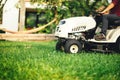 Landscaping details - man using professional tractor for cutting and trimming grass