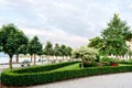 Landscaping of the embankment of the city with trimmed trees, shrubs and flower beds.