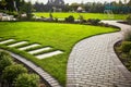 Landscaping of the garden. path curving through Lawn with green grass and walkway tiles. Royalty Free Stock Photo