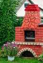 Landscaping in the garden. Red brick barbecue stove. Outdoor stone stove with grill. Outdoor recreation Royalty Free Stock Photo