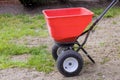 Sowing lawn grass seeds with a drop lawn spreader in the residential backyard