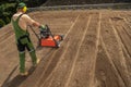 Landscaping Worker Preparing Backyard Garden Soil Using Aerator