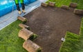 Landscaping Worker Rolling Out Turf Rolls in a Garden Royalty Free Stock Photo