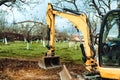 Landscaping works in the garden at construction site with mini yellow excavator Royalty Free Stock Photo