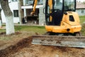 Landscaping works at home construction site using excavator and mini bulldozer