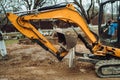 Landscaping works in the home garden at construction site with mini yellow excavator Royalty Free Stock Photo