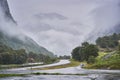 Landscpe picture of the asphalt crossroad in the norwegian mountains covered by clouds Royalty Free Stock Photo