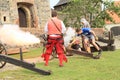 Landsknechts with visitor shooting from cannon Royalty Free Stock Photo