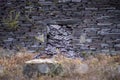 Landslide of purple roof slate in old Welsh quarry pile sliding through door of abandoned building. Royalty Free Stock Photo