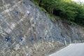 Landslide and rock sliding prevention in Georgia, reinforcing mountain slope with metal mesh. Royalty Free Stock Photo