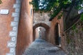 Lane leading from Piazza Comunale betweem exterior walls and under stone arch connecting bridge Royalty Free Stock Photo