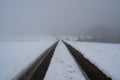 Lanes on a snow covered rural road on a foggy day in winter Royalty Free Stock Photo